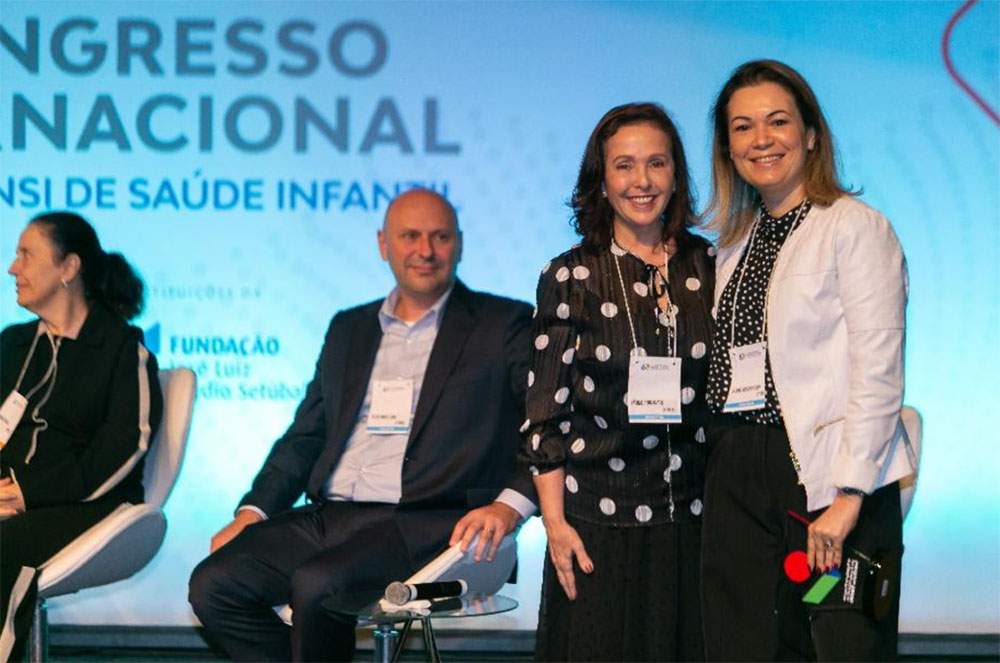 Uma premiada e uma representante do PENSI posam para foto.
